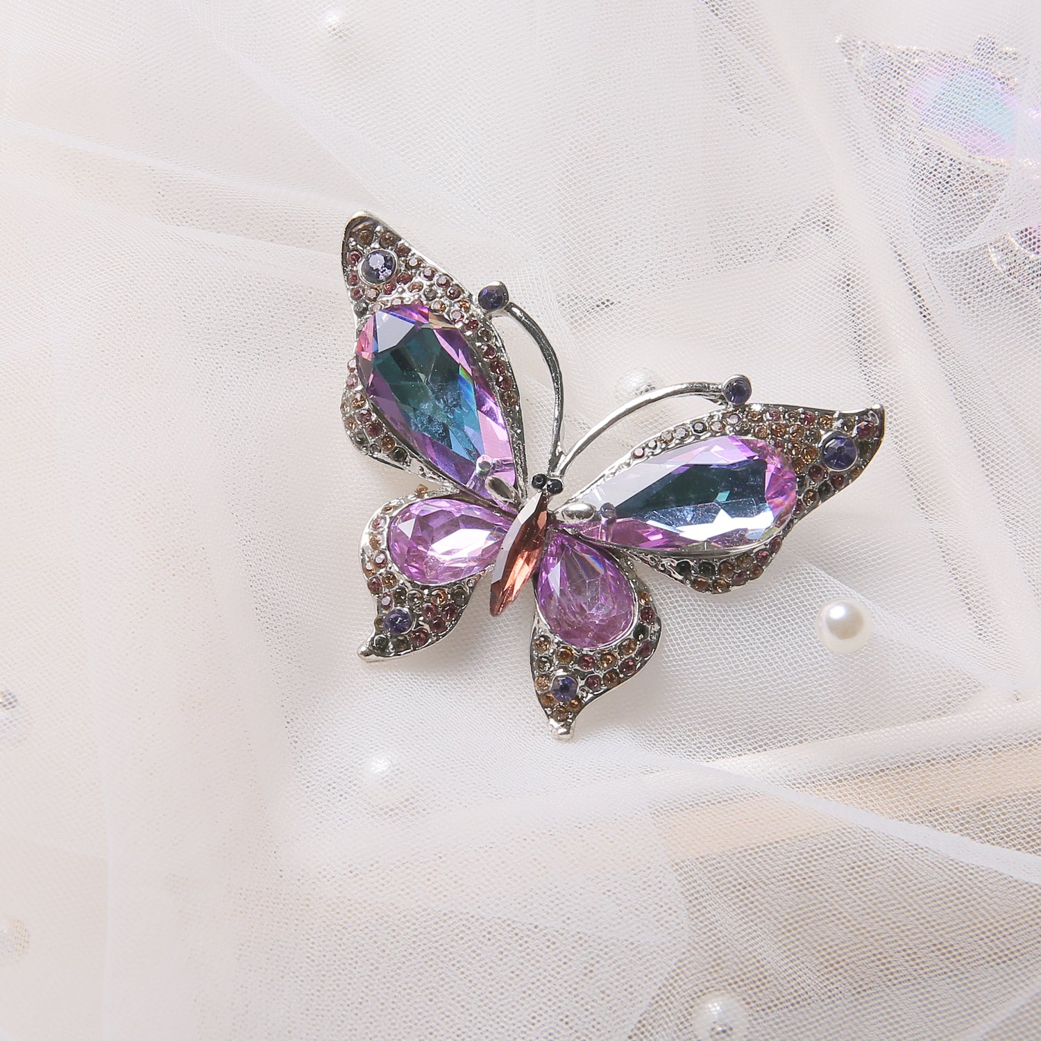 Elegant butterfly-shaped brooch with purple and pink gemstones on semi-transparent white fabric with small pearls, available at Lovful as Enchanting Fairy Queen Brooch
