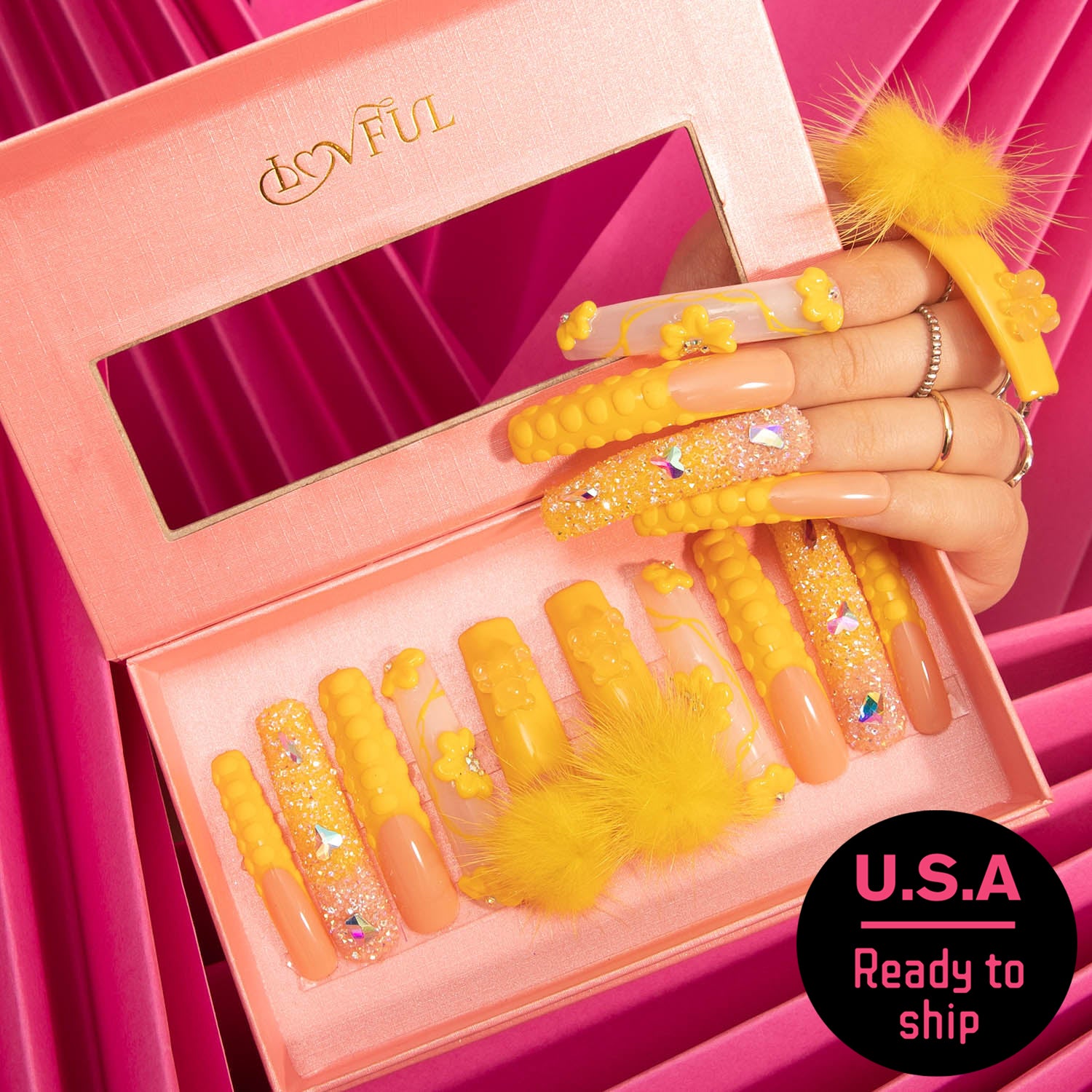 Yellow press-on nails from Lovful's 'Yummy' collection with detachable fluffy balls in a pink box, 'U.S.A Ready to ship' badge visible.