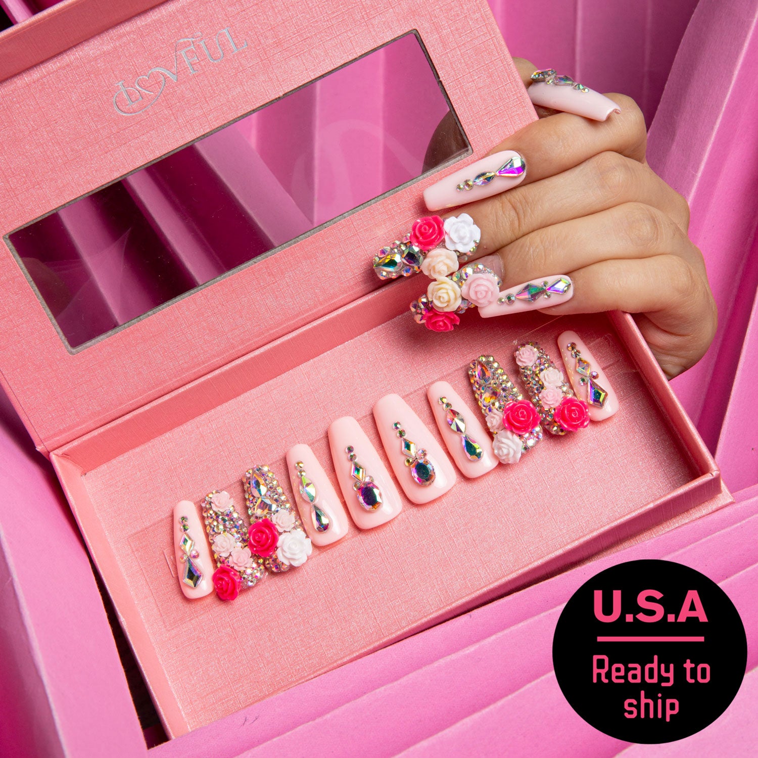 Coffin-shaped Rose Garden Bliss press-on nails in a pink box with rhinestones, roses, and colorful gems, labeled 'U.S.A Ready to ship'.