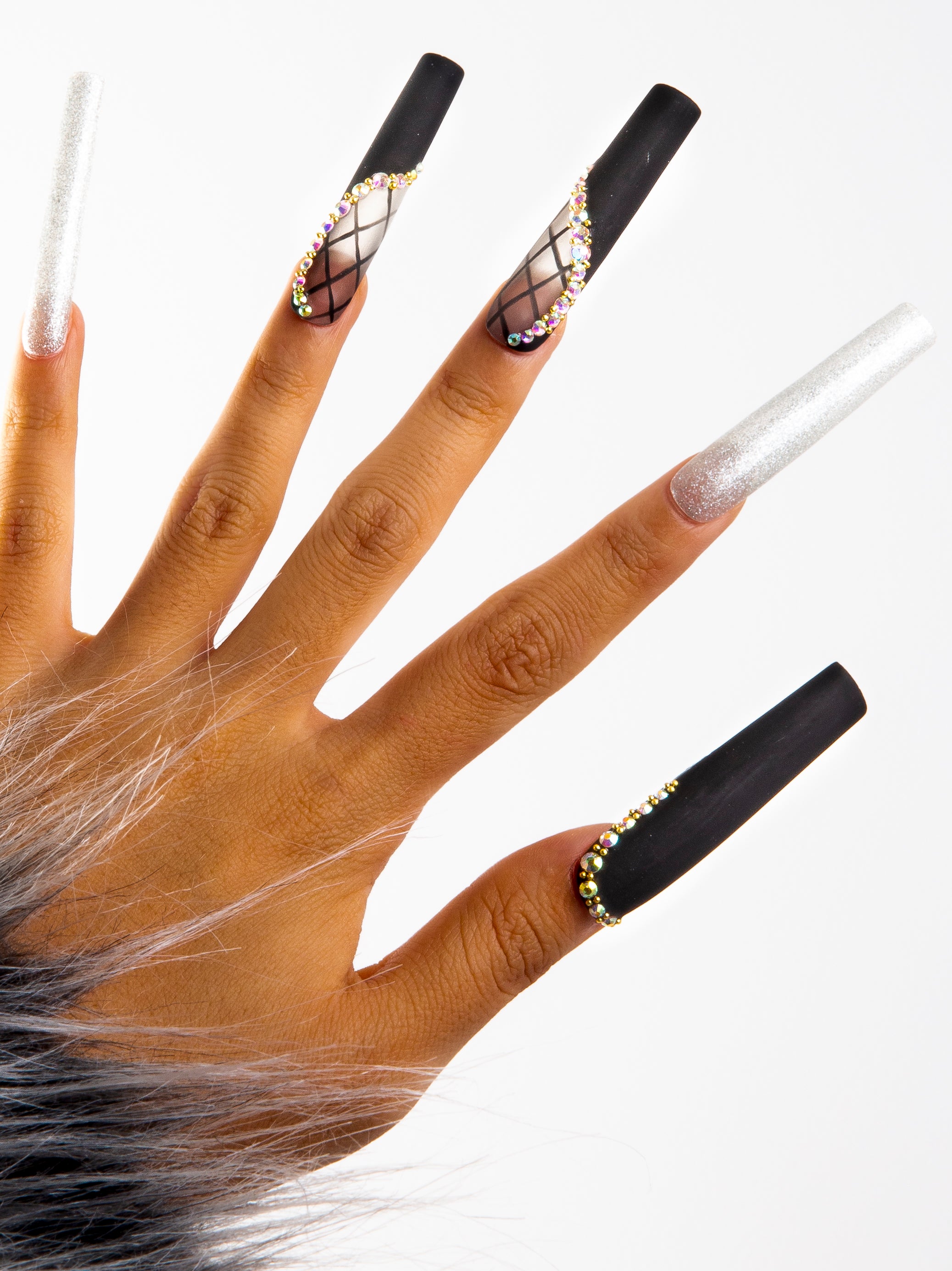Close-up of hand with Lovful H114 - Black Lace press-on acrylic nails featuring black lace decor, silver shimmer, and rhinestone accents. Fur cuff partially visible.