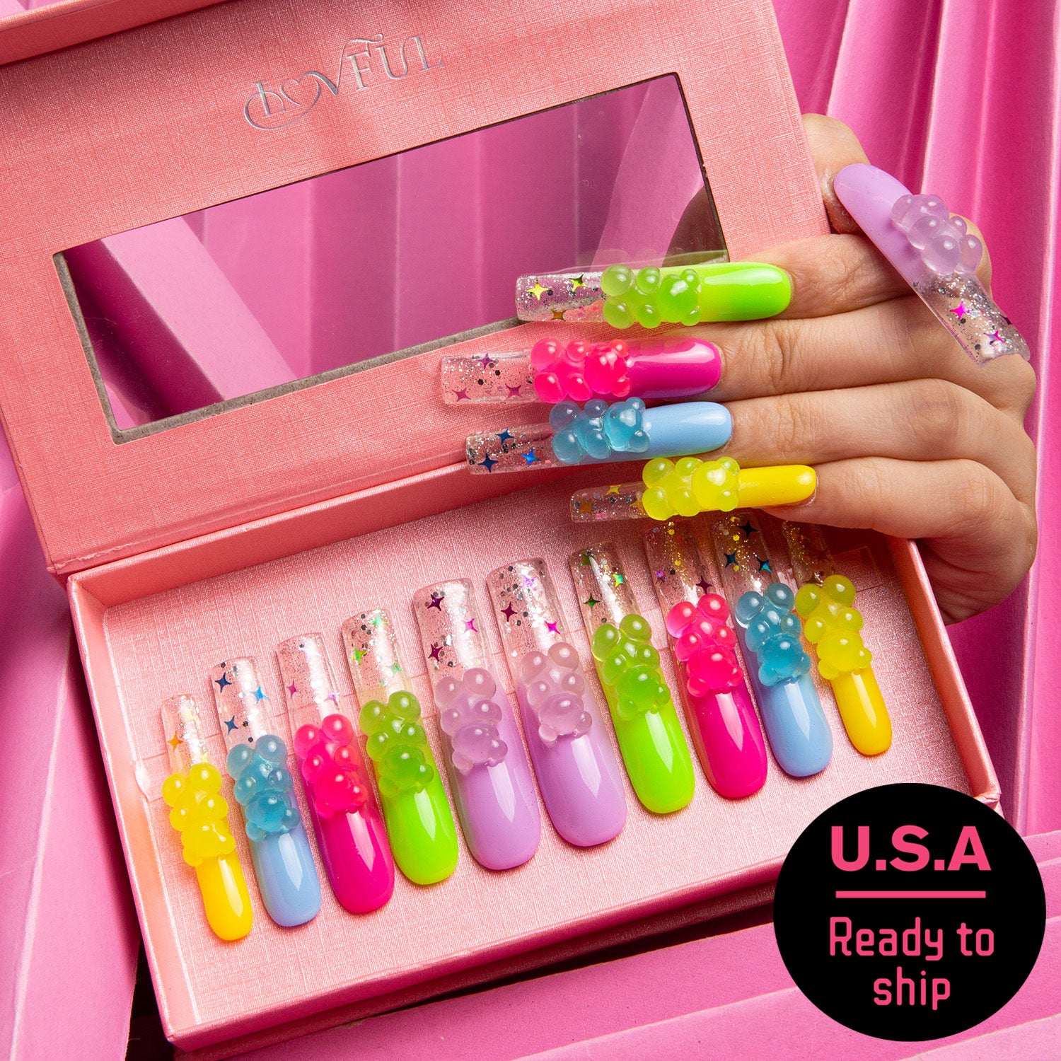 Sweet Wonderland press-on nails. An open pink box showcasing colorful nails varying from candy pink to sunshine yellow, each adorned with glowing gummy bear charms. U.S.A Ready to ship.