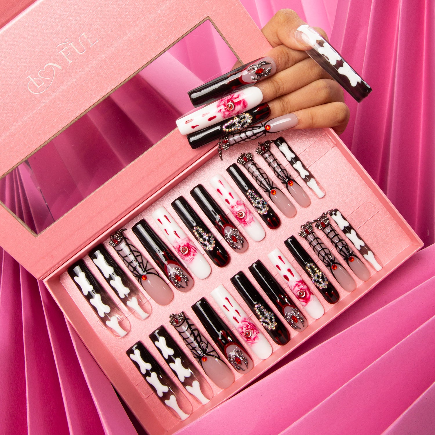 Set of 24 'Final Destination' press-on acrylic nails in a pink box, featuring red and black hues with eye, ghost, and bone patterns. A hand with some nails applied.