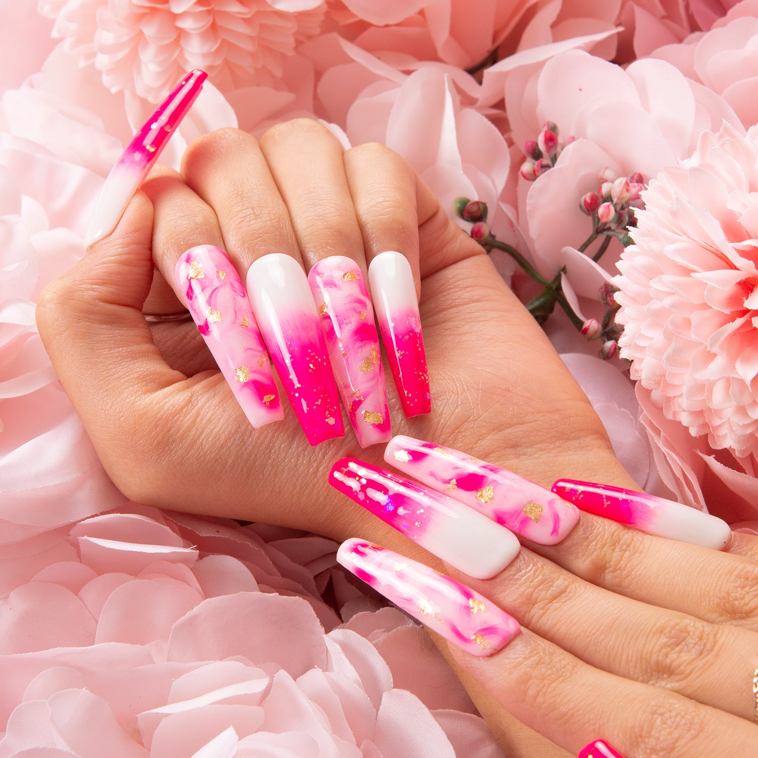 Long, coffin-shaped acrylic nails with a vibrant pink and white ombre design, featuring abstract pink swirls and delicate gold foil accents.