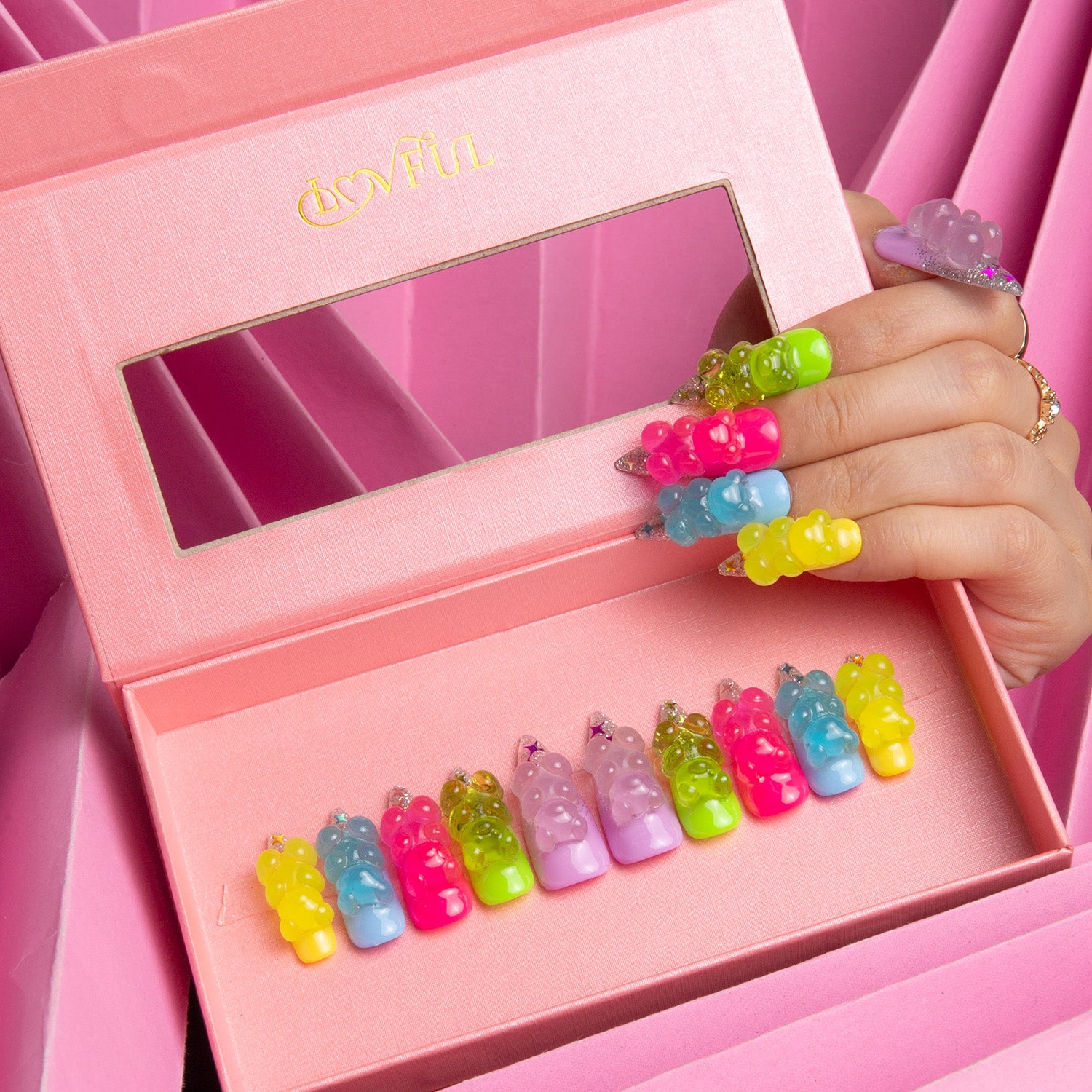 Set of colorful press-on stiletto nails from Lovful's 'Sweet Wonderland' collection, featuring gummy bear charms in a pink box.