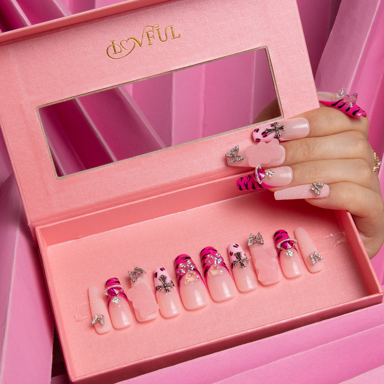 Safari Love press-on nails by Lovful, featuring hot pink French tips with leopard prints, lips, butterflies, and rhinestones, presented in a pink box.