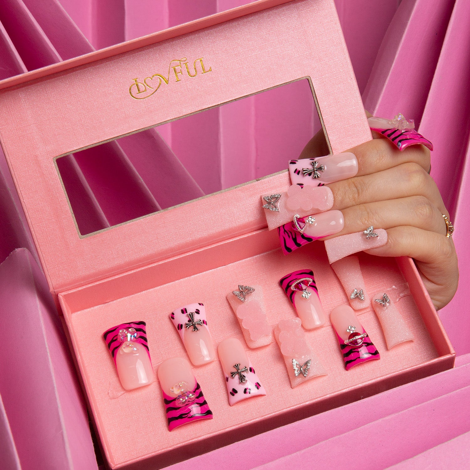 'Safari Love' press-on nails in pink box with hot pink French tips, leopard prints, lips, and butterfly accents, displayed on a hand.