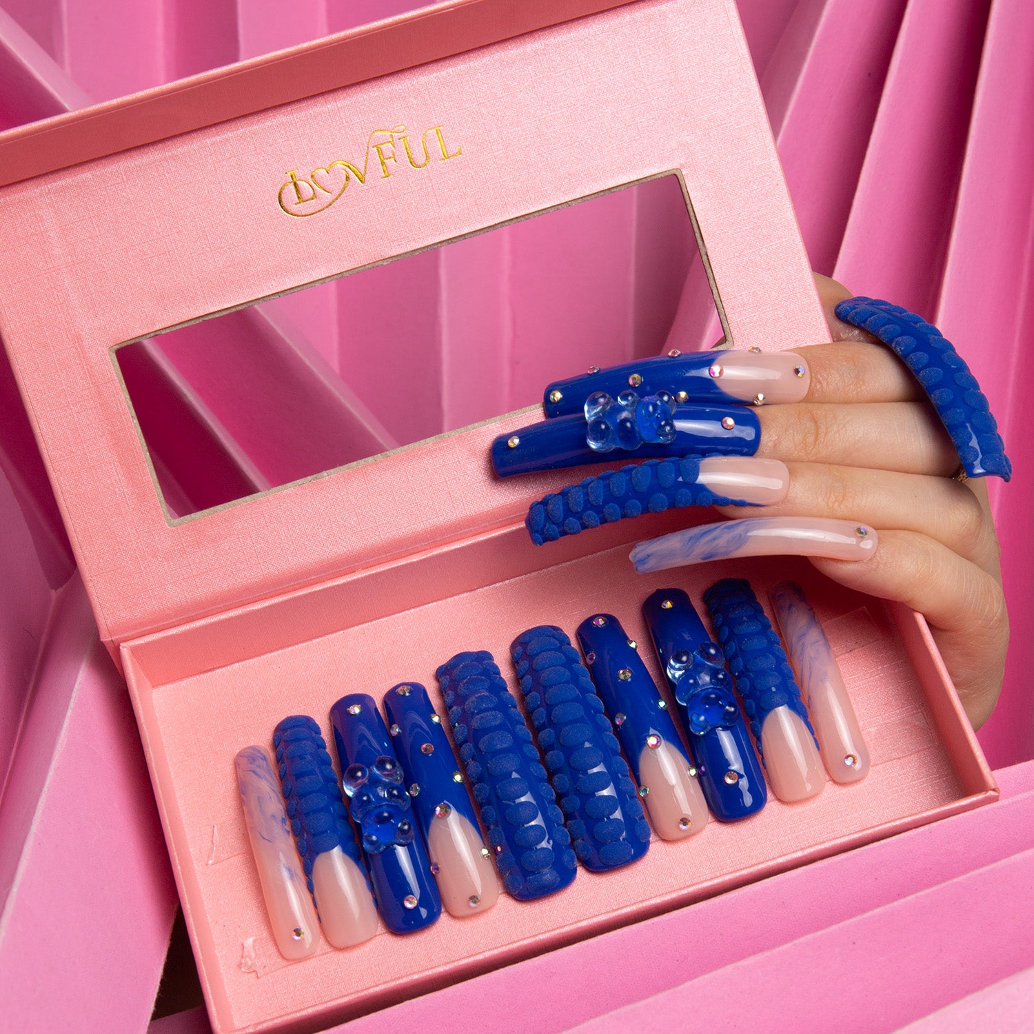 Lovful Little Blue Bear Curve press-on nails with blue French tips, decorated with rhinestones, gummy bears, and 3D dots, displayed in a pink box with a mirror.