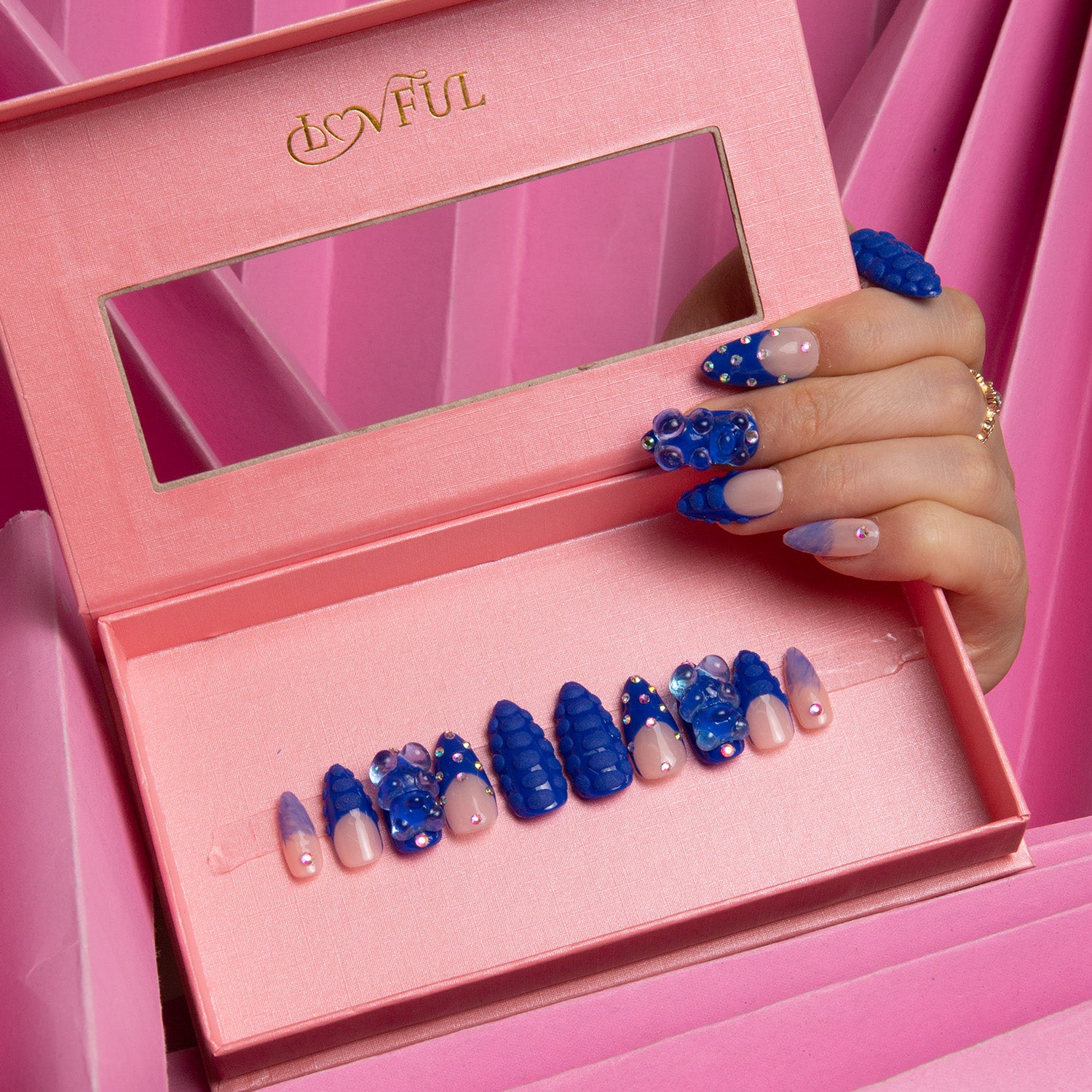 Set of 'Little Blue Bear' press-on nails by Lovful in a pink display box, featuring blue nails with gummy bear decorations and shiny rhinestones.