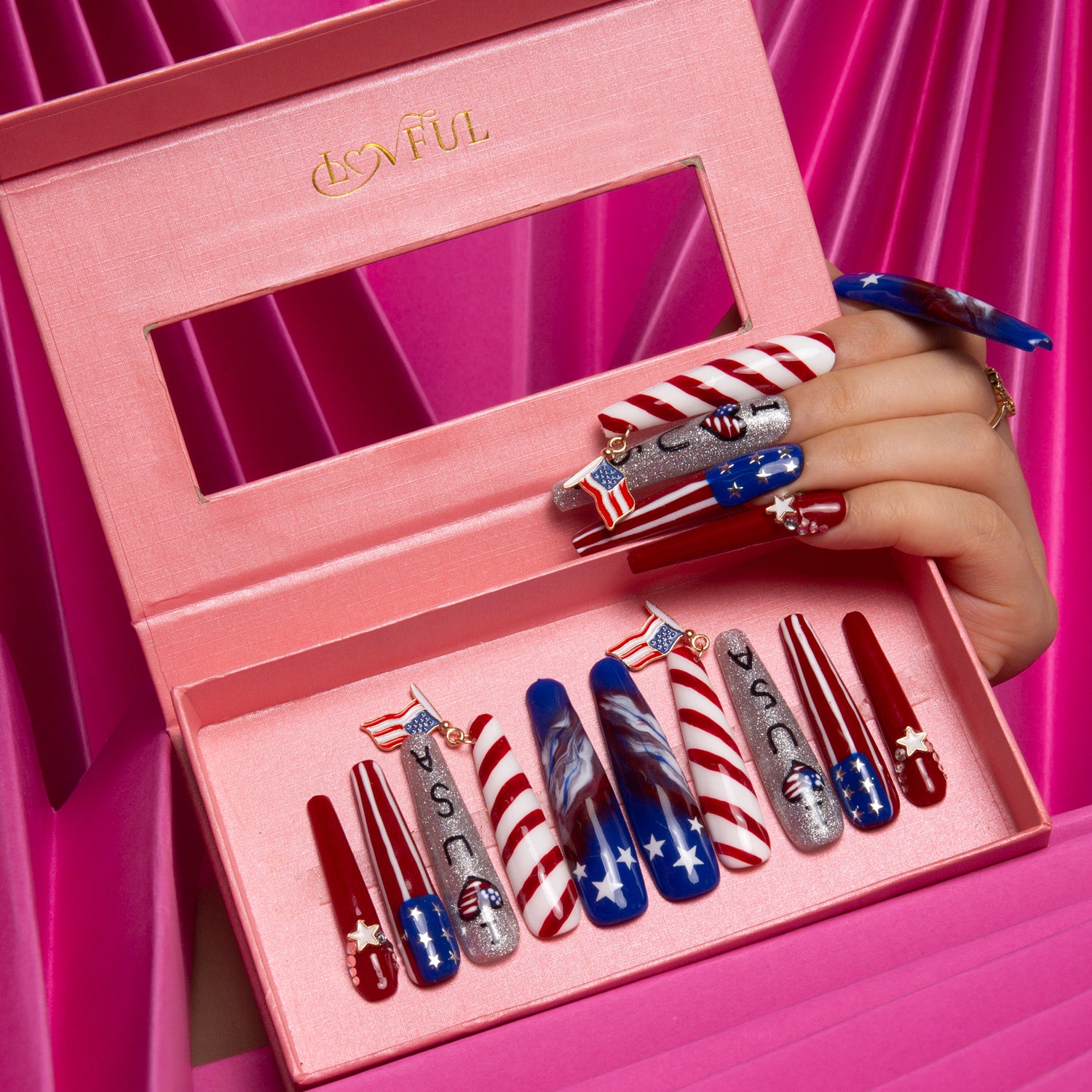 'American Dream' press-on nails from Lovful in a pink box, featuring red, white, and blue patriotic designs with stars, stripes, and USA letters, perfect for National Day and July 4th celebrations.