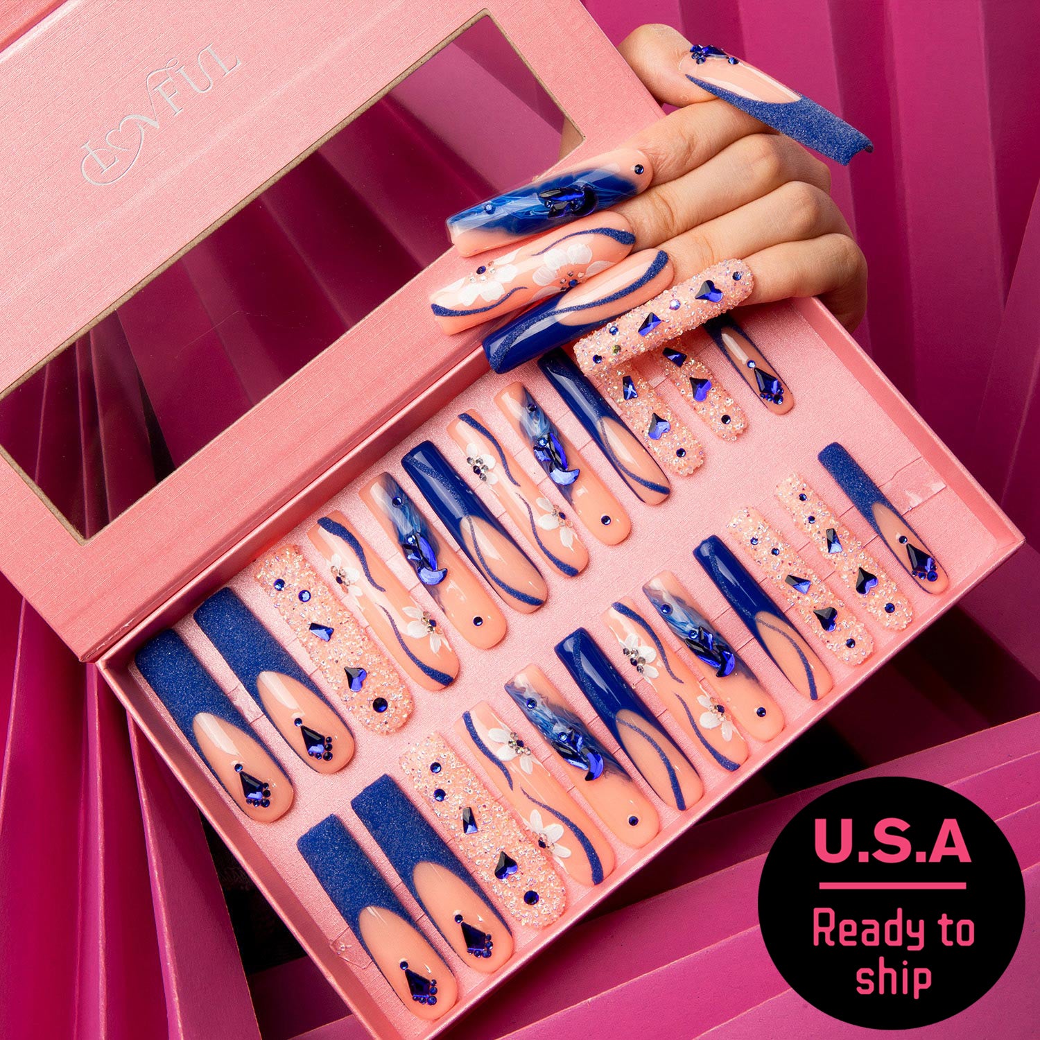 24-piece set of Lovful 'Blue Suede' press-on nails featuring blue French tips with curvy lines, crystals, and blue heart-shaped gems, in a pink box with a hand showing the nails and a 'U.S.A Ready to ship' sticker