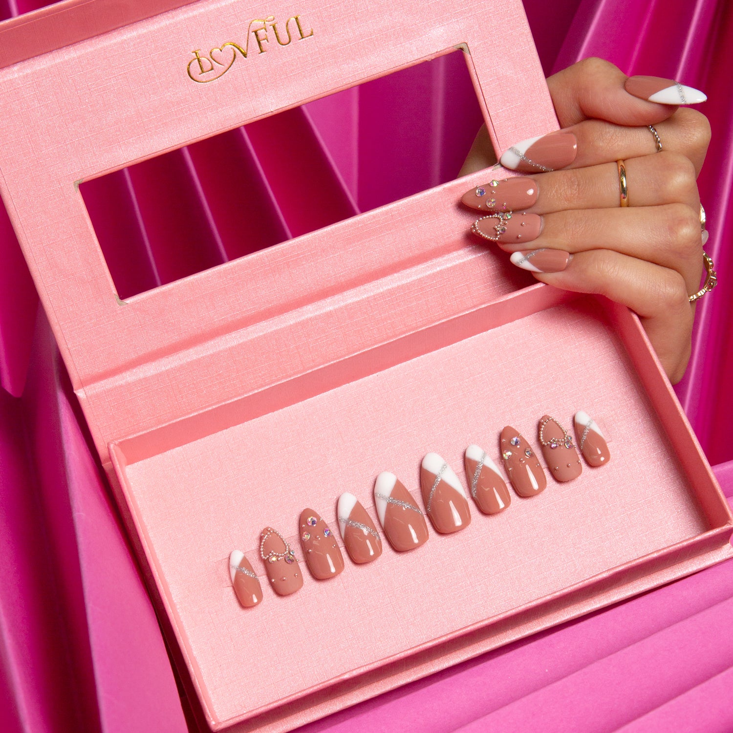 Almond-shaped press-on nails with classic French tips and subtle glitter, displayed in a pink box with a 'Lovful' brand name. Vibrant pink background.