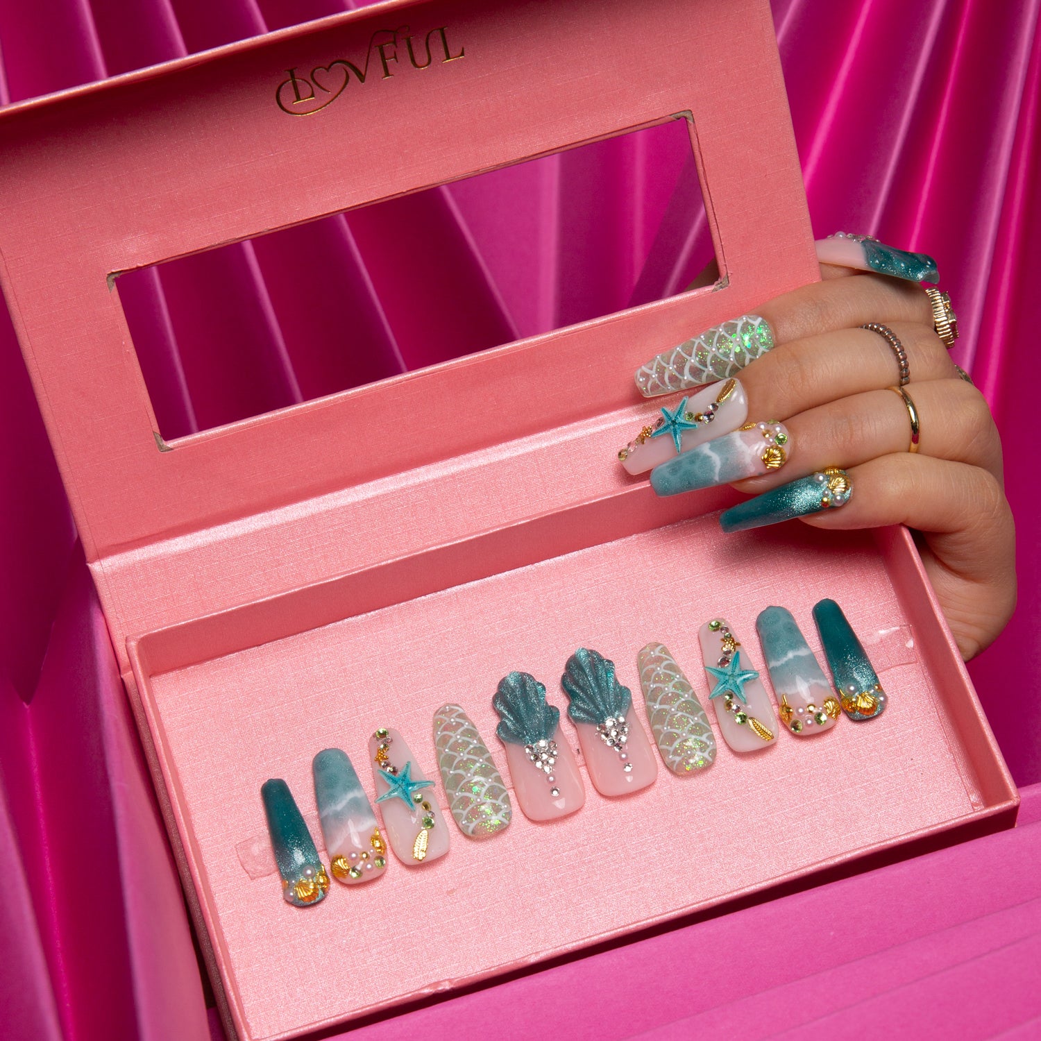 'Surfing Girls' press-on nails in a pink box, featuring a Hawaii sea blue base color with starfish, shells, and glitters, giving a joyful beach vibe.