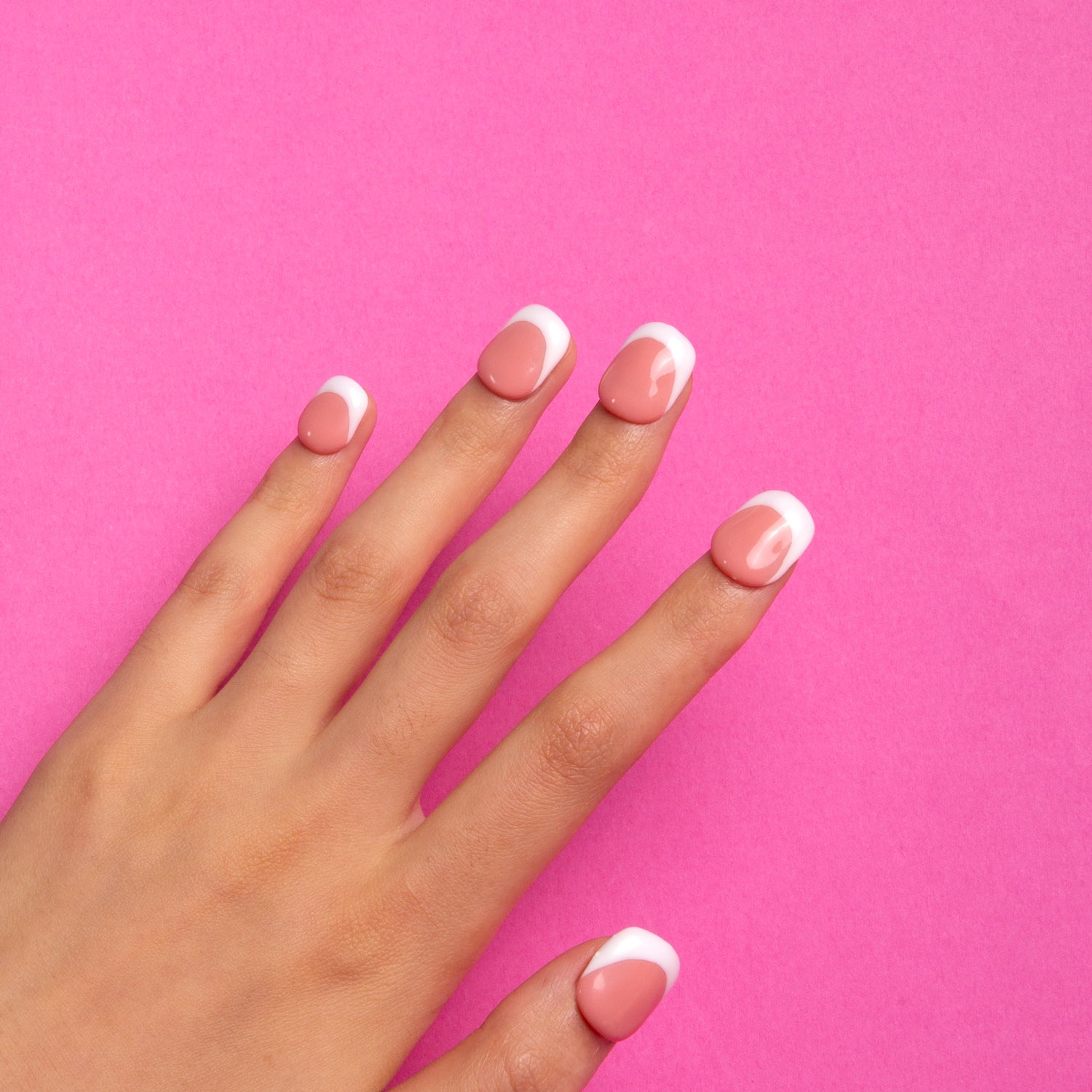 Hand with Coffee Latte French Tip Press-On Nails against a pink background, showcasing square-shaped nails with white tips and coffee-colored bases for a chic, elegant look.
