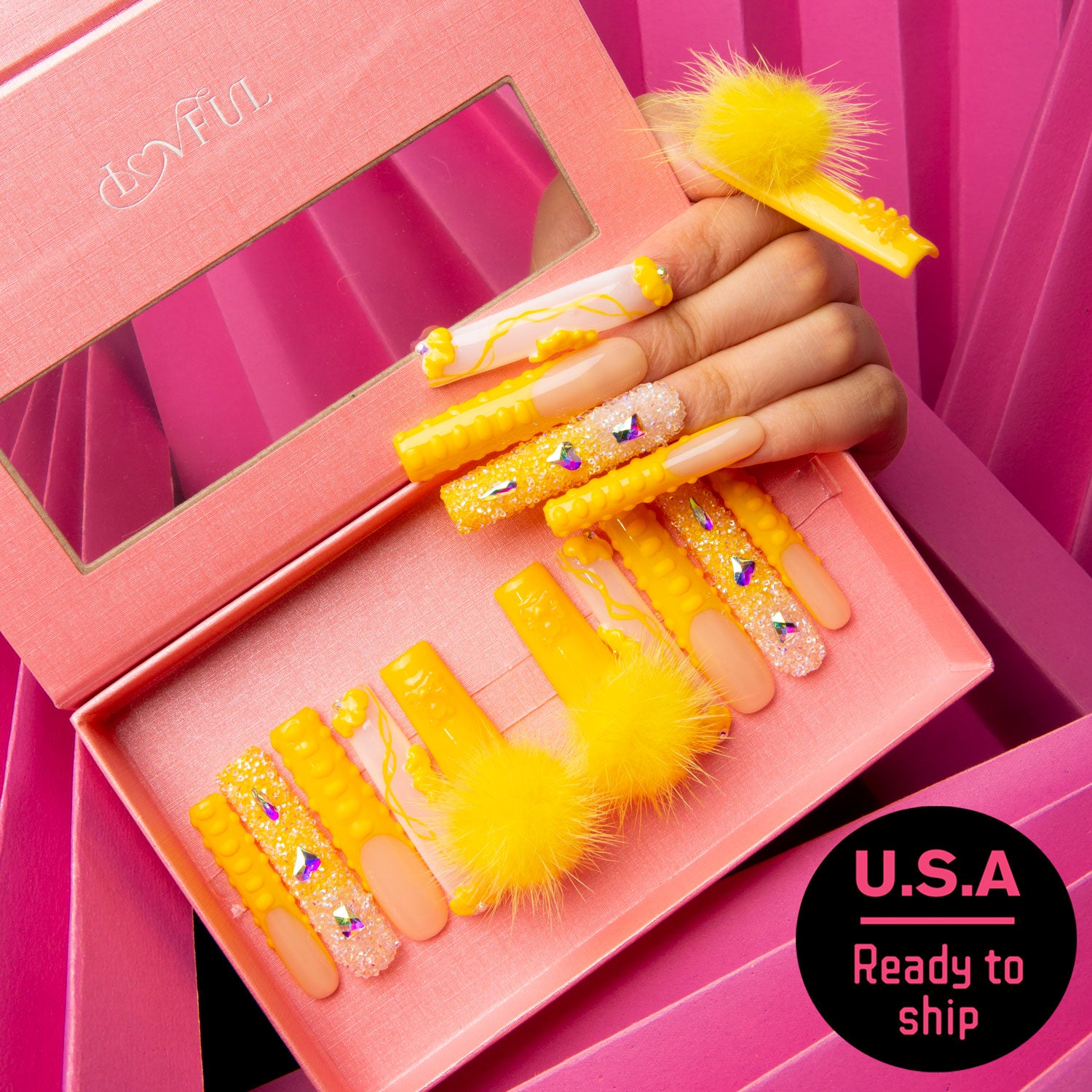 Sunny yellow press-on nails with detachable fluffy balls and glitter in a pink box from Lovful's 'Yummy' collection. Ready to ship in the U.S.A.