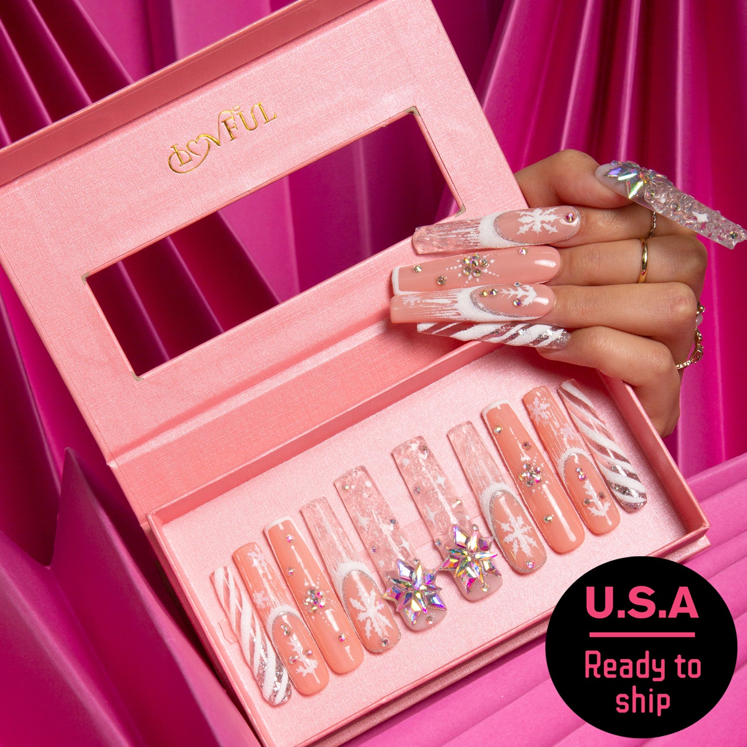 Hand wearing Lovful Snowy Moonlight press-on nails with winter-themed designs, showing the U.S.A ready-to-ship label. Extra press-on nails in pink box with Lovful logo.