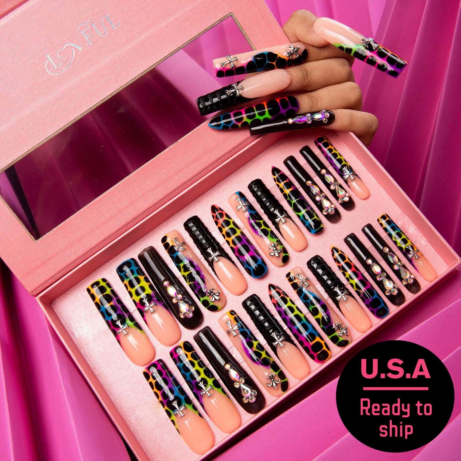 24 press-on nails with black French tips and vibrant animal prints from Lovful's 'Young Forever' collection in a pink box. A hand shown wearing some of the nails. 'U.S.A Ready to ship' text in lower right corner.