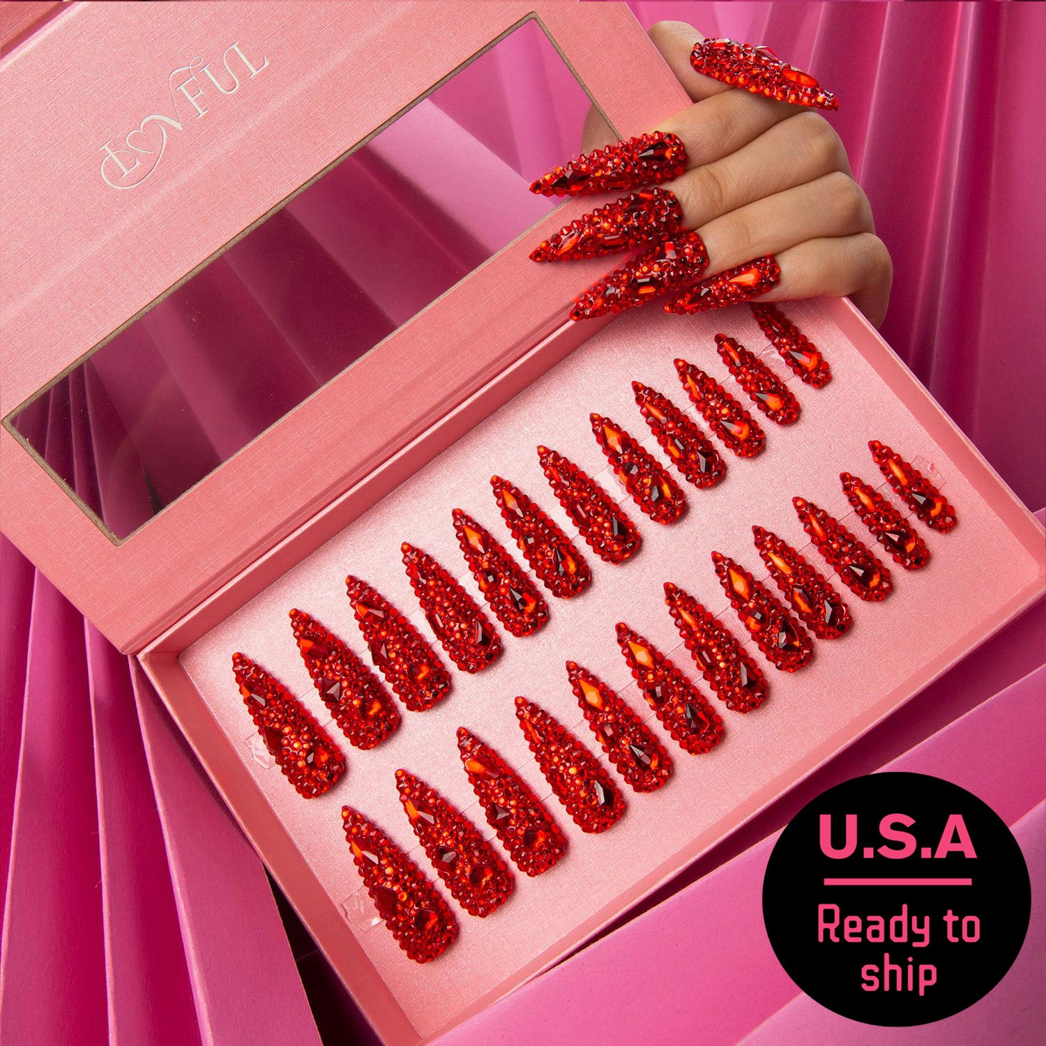 24 pcs Flaming Sex press-on nails set in a pink box. Each nail is adorned with vibrant red rhinestones. Hand displaying some nails. Text reads 'U.S.A. Ready to ship'.