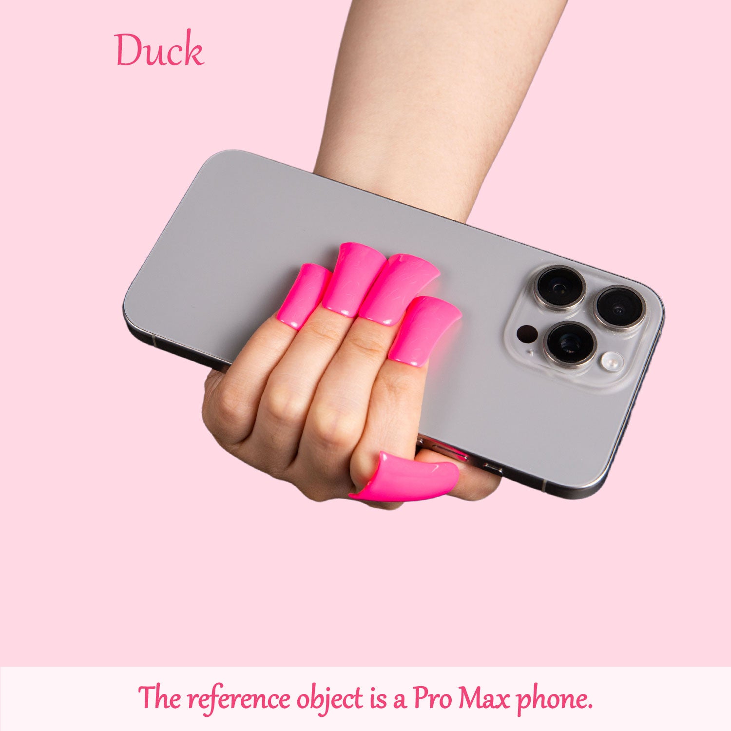 Person's hand with vibrant pink press-on acrylic nails holding a Pro Max phone against a light pink background with text 'Duck' and 'The reference object is a Pro Max phone.'